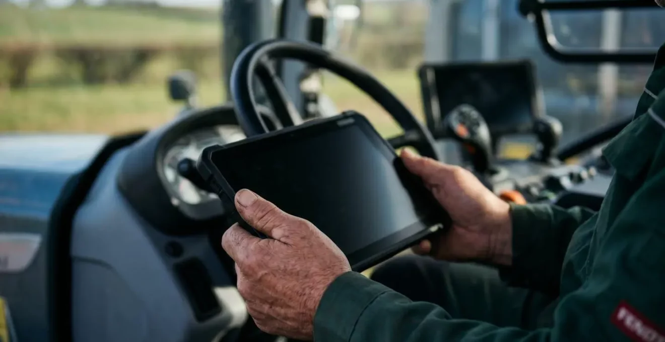 Landwirt nutzt digitale Ackerschlagkartei auf Tablet im Traktor für lückenlose Pflanzenschutzdokumentation